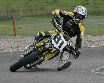 a motorcyclist leaning into a corner to counteract the body force